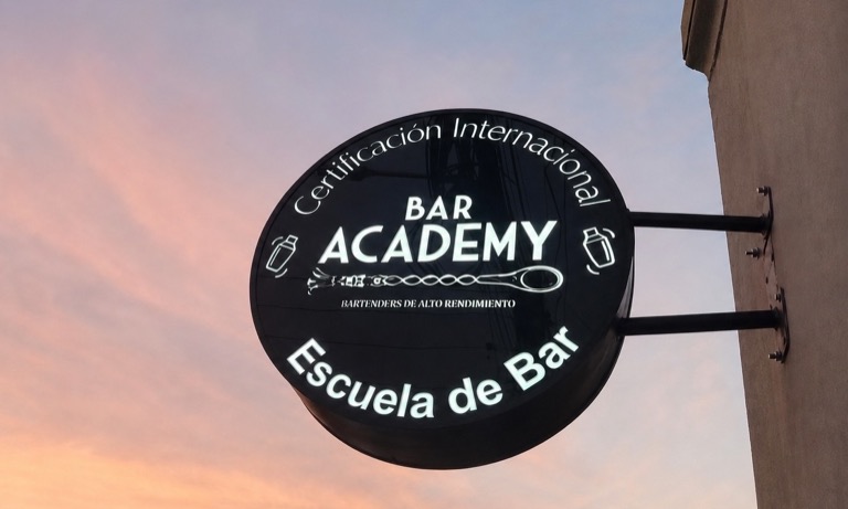 Letrero luminoso exterior de Bar Academy centrado sobre un fondo limpio